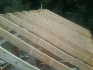 New roof rafters set over an addition before sheathing in Bowers