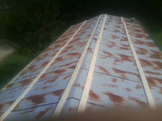 Rusted metal roof panels with new wood purlins before replacement — Storm Damage Roof Repair in Bowers by Roofing Brothers