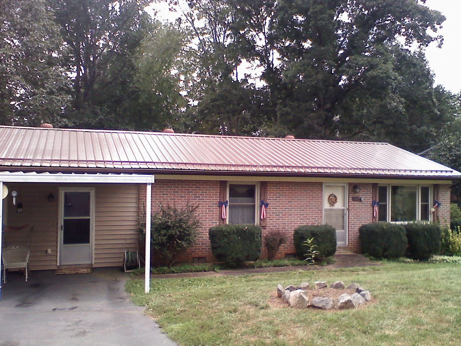 Bronze metal roof and carport on a brick ranch home — Roof Repair work by our crew in Bowers