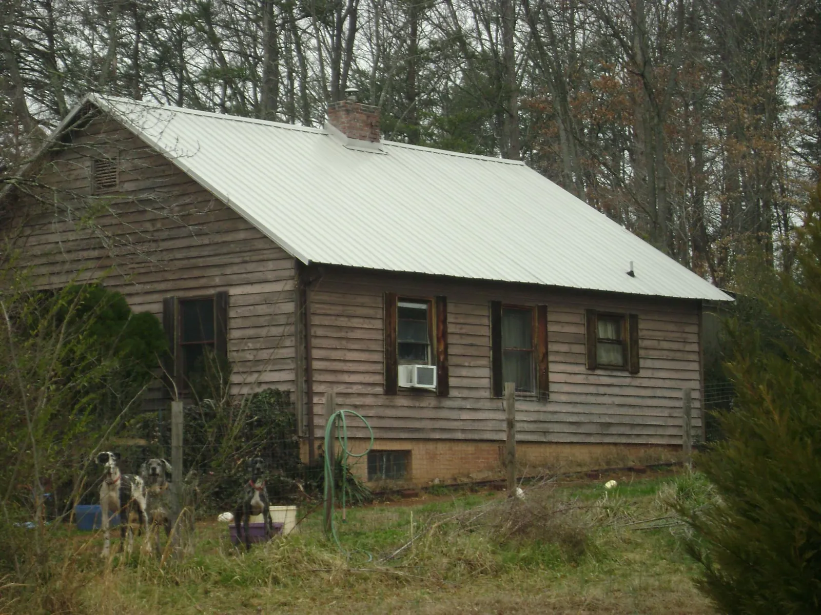 White metal roof on an old wood sided farmhouse, from a Metal Roof Installation job in Bowers